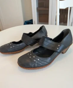 Svarta pumps med rem och nitdetaljer