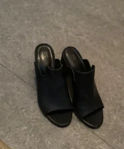 Svarta sandaler som tofflor