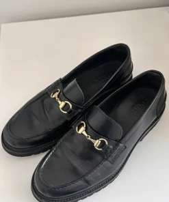Vinny’s sorte loafers med guld spænde